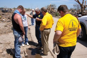 From left, two victims of the May 20, 2013 Moore tornado are prayed over by Baptist General Convention of Oklahoma (BGCO) Disaster Relief Director Sam Porter, BGCO Executive Director-Treasurer Anthony L. Jordan and another BGCO official. The BGCO cleared the home sites at no charge of more than 1,200 of the 4,035 houses that were reported destroyed or damaged by the tornado (Photo: Brian Hobbs)
