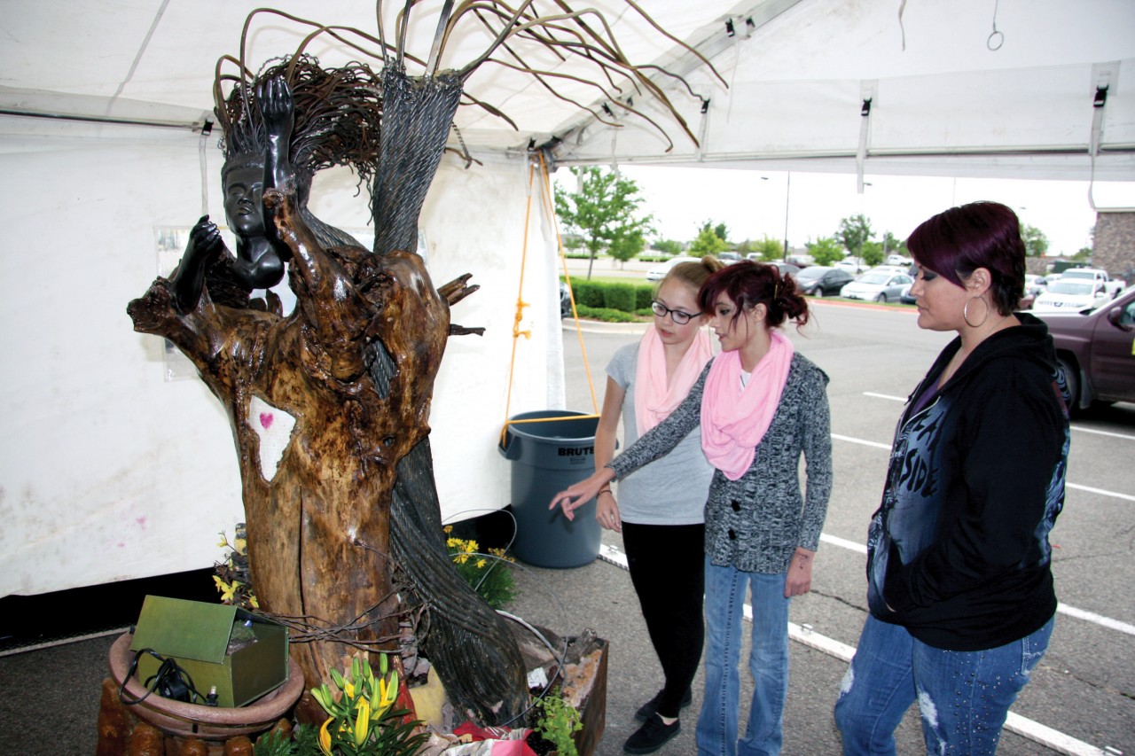 From right, Tara Fanning, Alexis Fanning and Hayden Gardiner, look at the “Rising from the Rubble” sculpture made by a local artist. The sculpture, which was featured in the film, was made from pieces of rubble after the storm and family photos from those affected by the tornado. 