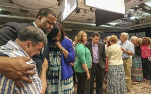 Roger Wall, left, embraces Dante and Schenita Randolph during a time of prayer for the 95 International Mission Board and North American Mission Board missionaries commissioned during a Woman's Missionary Union Celebration June 8 at the Baltimore Convention Center. Wall, pastor of Providence Baptist Church in Pageland, S.C., served in Durham, N.C., where the Randolphs serve as missionaries at Grace Park Church. Photo by Bill Bangham.