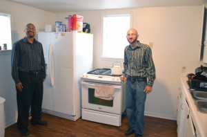 Assistant Director Jeff Elbert, left, and Senior Pastor Rick Gettens display the result of months of a labor of love by members of Lawton, Mind of Christ Multiethnic to repair one of the units of the Living Life: Housing with a Purpose program in the living room and kitchen of the first residence to house a participant in the program.