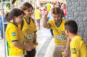 photo: Wilson Hunter Student volunteer Grant Gilliam raises a yellow card—resembling what a referee uses to call a rule violation in a soccer match—to get the attention of a soccer fan near Rio de Janeiro’s Maracana Stadium. Gilliam and his teammates, from left, Bianca Brandao and Stephanie Silva, a student at Oklahoma Baptist University, shared the Gospel before a World Cup match.