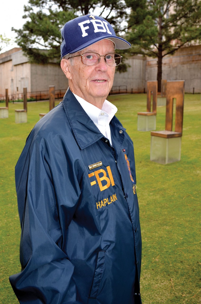 Williams in his FBI chaplain jacket and cap stands among the Field of Empty Chairs, which memorializes those who perished. (Photo: Bob Nigh)