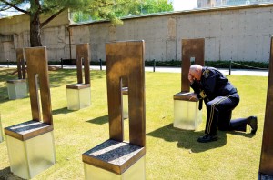Jack Poe prays beside the memorial chair for Secret Service Agent Mickey Moroney, who was killed in the Murrah bombing (Photo: Bob Nigh)