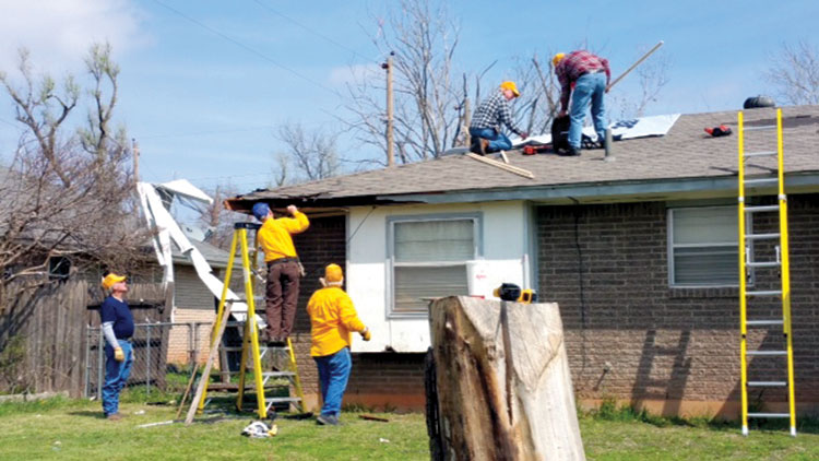 Recovery & repair team members, from left, Richard Cavett, Ivan Armstrong, Carl Bastion,Robert Harshman and Paul Gustafson place tarp on a roof (Photo: Joe Day)