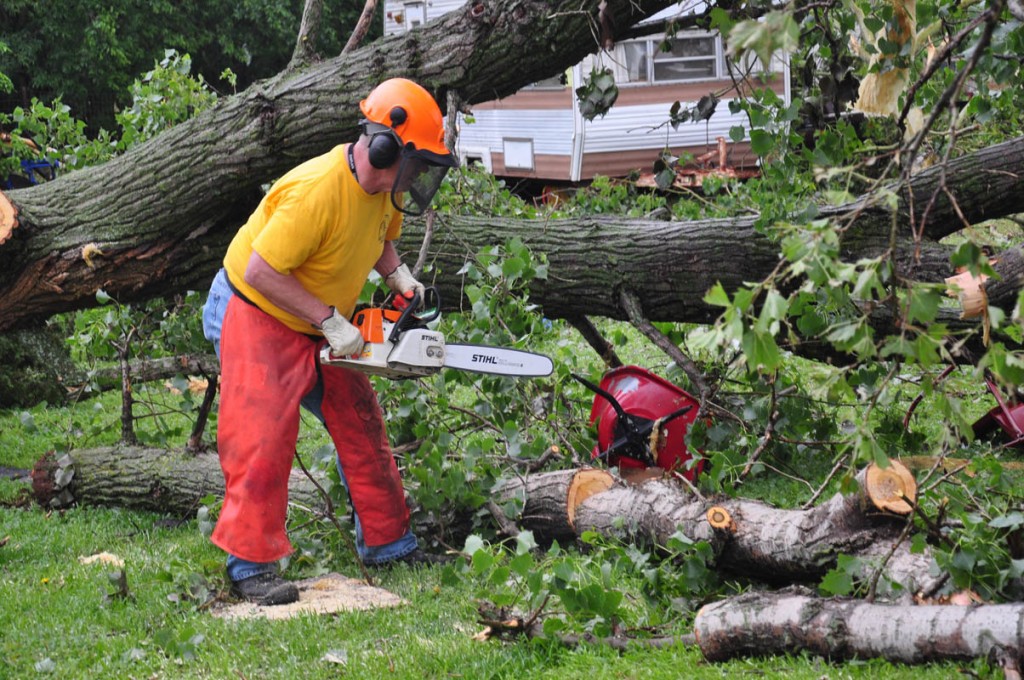 Dennis Troyer with Oklahoma Baptist disaster relief unit works on cutting up a fallen tree in the Bridge Creek area. (Photo: David Crowell)