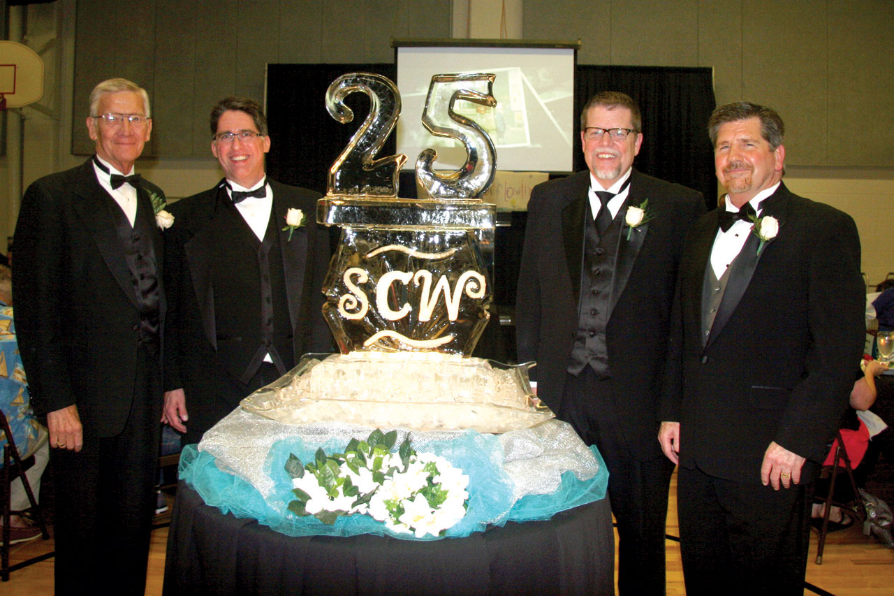 Lind, right, poses with former directors, from left, Bill Green, Bart Morrison and Ken Gabrielse around the special 25th Anniversary ice sculpture (Photo: Dana Williamson)