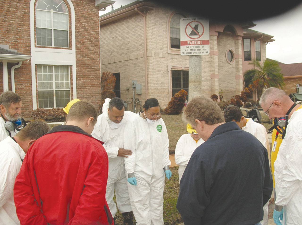 Luter and his wife, Elizabeth, right, are prayed over before Oklahoma DR volunteers begin to “mud-out” their home in 2005. (Photo: Messenger File)