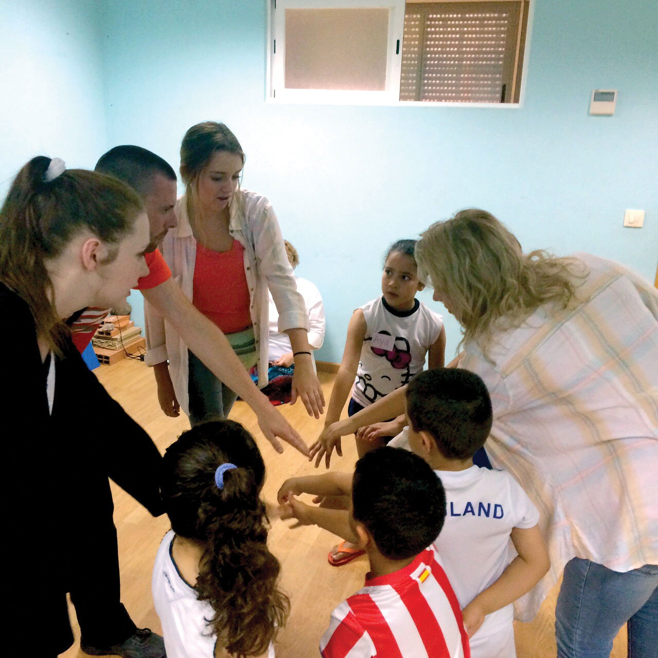 Members of Madrid team teach children a rally cheer at English Camp. (Photo: Provided)