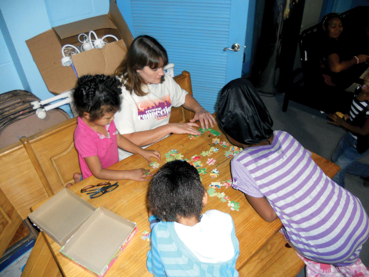 Bennett works with client children in the Friendship House to put together a puzzle. (Photo: Provided)