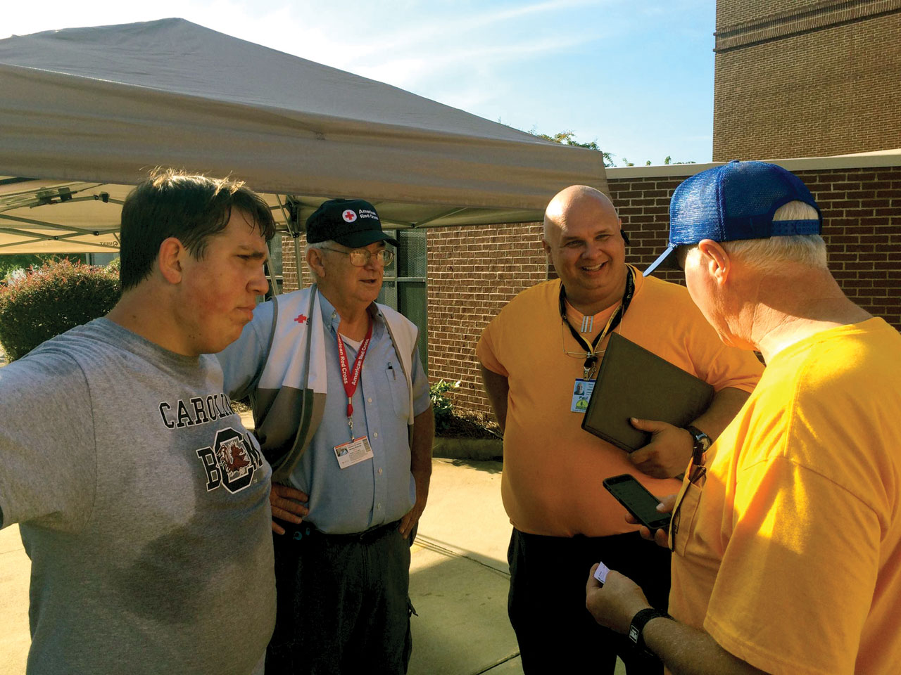Steve Wise and Paul McKee, right, both South Carolina Blue Caps, discuss feeding plans with American Red Cross Kitchen Manager Bobby Roberts, second from left, and a local volunteer. The kitchen was set up at Riverland Church in Irmo, S.C. (photo: SBDR)