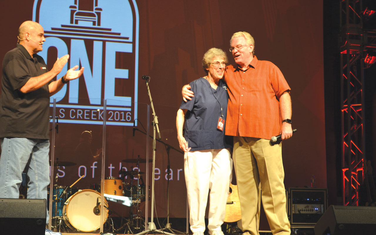 She was recognized by Anthony Jordan, BGCO executive director-treasuer, right, along with Andy Harrison, Falls Creek Summer Camp program director, left, during an evening service, as they announced the First Aid Building will be named after her. Photo: Chris Doyle