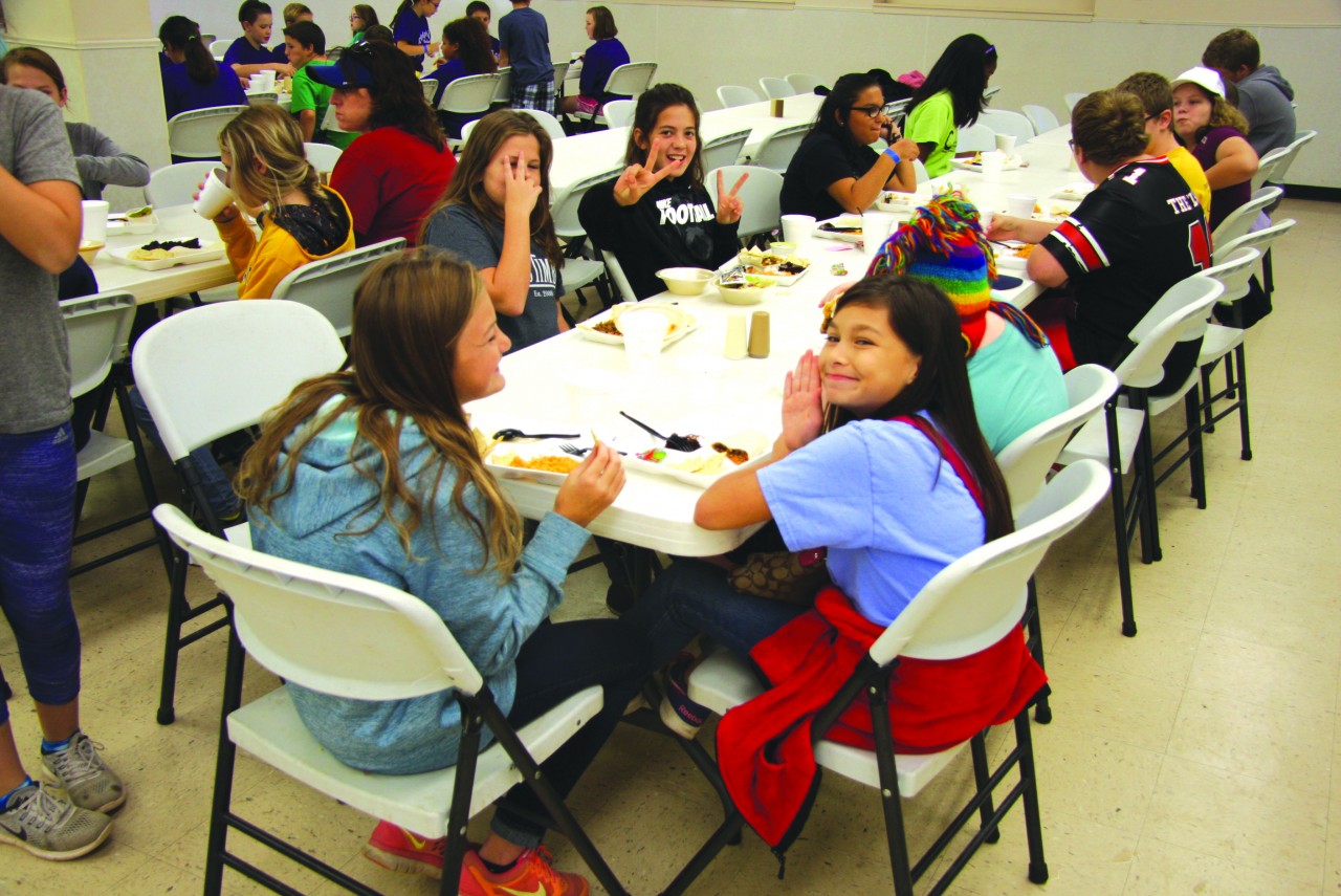 Campers enjoy fellowship over a meal at CrossTimbers.