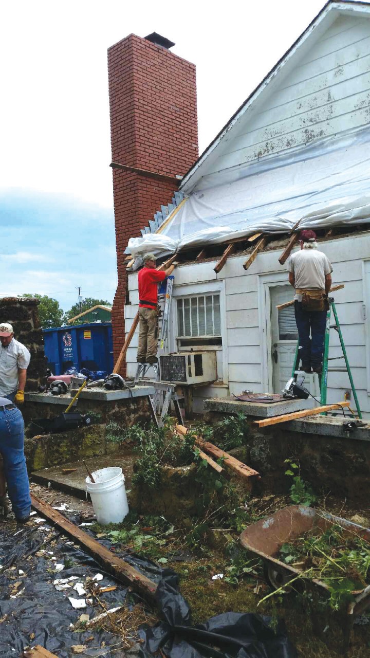Masham members put a roof on a neighboring house as a ministry of outreach.